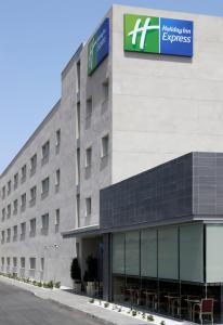 a large building with a sign on the side of it at Holiday Inn Express Málaga Airport, an IHG Hotel in Málaga