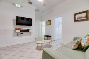 een woonkamer met een bank, een tafel en een tv bij Atocha Cottage - Harbor Walk Hideaways in Key West