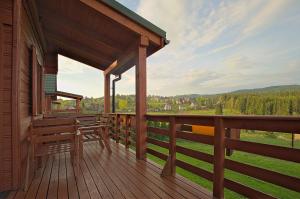 a porch of a cabin with a view of the mountains at Domki Krótki Szpic in Istebna