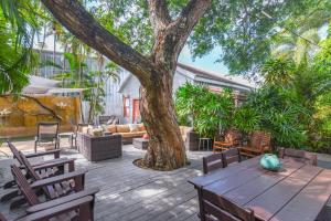 een patio met een boom en een tafel en stoelen bij African Queen - Harbor Walk Hideaways in Key West +4 foto's