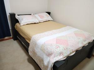 a bed with a quilt and two pillows on it at Miah Accommodation in Galesburg