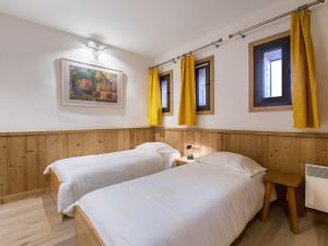 2 letti in una camera con pareti e finestre in legno di Appartement 3 chambres au centre de Megève avec terrasse et Wifi - FR-1-453-316 a Megève