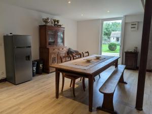 a kitchen with a wooden table and a refrigerator at Gîte Authentique à Villemurlin avec Jardin et Parking - FR-1-590-527 in Villemurlin