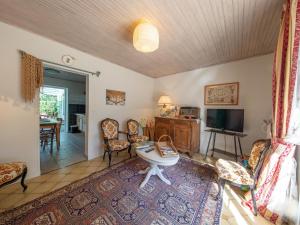 a living room with a table and chairs and a tv at Chambres et Suites au Calme avec Wifi et Animaux Acceptés - FR-1-590-475 in Saint-Benoît-sur-Loire