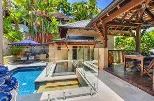 an outdoor patio with a pool and a house at Far Pavilions - An Intimate Bali-style Haven in Port Douglas