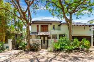 a house with trees in front of it at Far Pavilions - An Intimate Bali-style Haven in Port Douglas