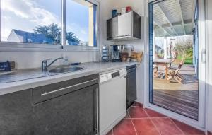 una cucina con lavandino e una porta che conduce a un patio di Gorgeous Home In Le Tour-Du-Parc a Le Tour-du-Parc