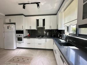 a kitchen with white cabinets and a white refrigerator at Villa's Tomris in Ortaca