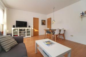 una sala de estar con un sofá y una mesa en Bungalow-Beatrice, en Norddeich