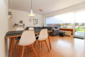 Un comedor y una sala de estar con mesa y sillas. en Bungalow-Beatrice, en Norddeich