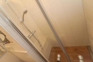 y baño con ducha y cabezal de ducha. en Bungalow-Beatrice, en Norddeich 5 fotos más