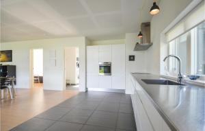 a kitchen with white cabinets and a counter top at Holiday Home Spovevej Ebeltoft Ii in Ebeltoft