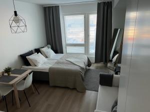 a bedroom with a bed and a table and a table and chairs at StyleStudio Areena1 in Tampere