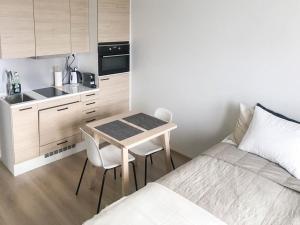a small kitchen with a table and a bed in a room at StyleStudio Areena1 in Tampere