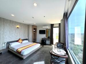 a bedroom with a bed and a desk and a window at Hotel Stylish Tân Khai in Hớn Quản