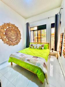 - une chambre avec un lit vert et une fenêtre dans l'établissement Rwanda Guest House Kanombe, Kigali, à Kigali