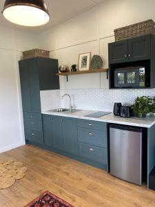 a kitchen with blue cabinets and a sink at Cosy guest house in Feilding