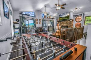 una sala de estar con una gran sala con mesa y chimenea en Distiller'S Den Cabin Cabin, en Gatlinburg