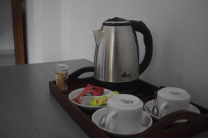 a tray with a tea kettle and cups on a table at Villa Shiny Aura - Hikkaduwa in Hikkaduwa