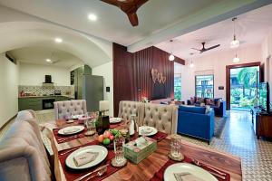 a dining room with a table and a living room at Melhor Stays Villa - L-A3 Luxurious 3BHK villa with private pool, Assagao in Vagator