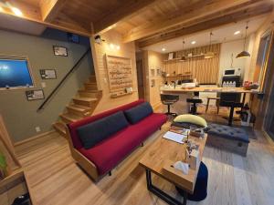 a living room with a red couch and a table at Rexline中辺路 in Tanabe