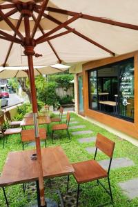 a patio with tables and chairs and an umbrella at Old Town Chiangmai Boutique in Chiang Mai