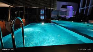 a large swimming pool with blue water at night at BORNEO Sutera Bay in Kota Kinabalu