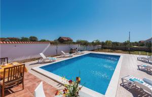 una piscina con sedie e tavolo di Four-Bedroom Holiday Home In Cista Velika a Velika Čista Altre 24 foto