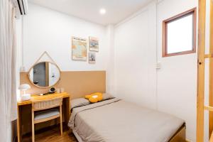 ein kleines Schlafzimmer mit einem Bett und einem Spiegel in der Unterkunft Double N Homestay in Ho-Chi-Minh-Stadt