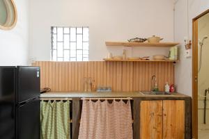 eine Küche mit einem schwarzen Kühlschrank und einer Spüle in der Unterkunft Double N Homestay in Ho-Chi-Minh-Stadt + 67 Fotos