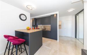 cocina con encimera con taburetes y reloj en Lovely Apartment In Okrug Gornji, en Trogir