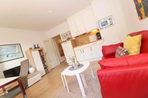Una sala de estar con un sofá rojo y una mesa. en Westerriede, en Norddeich