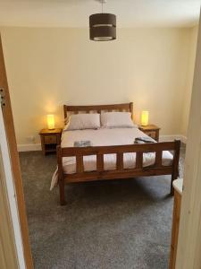 a bedroom with a bed with two lamps on two tables at Modern 3 Bedroom Property centrally based in Balivanich