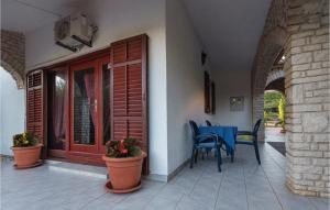 a patio with a table and chairs on a house at Holiday Home Krse Cr in Premantura