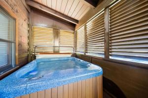 una grande vasca blu in una stanza con finestre di ER81 - Family Making Memories cabin a Pigeon Forge Altre 45 foto