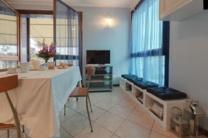 comedor con mesa y TV en Bellavista Apartment, en Marina di Ravenna
