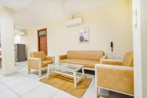 a living room with a couch and a table at FabHotel Prime AM Suites - Nr Yashoda Hospitals in Hyderabad