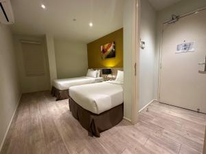 a hotel room with two beds and a walk in shower at SGI Vacation Club Hotel in Malacca