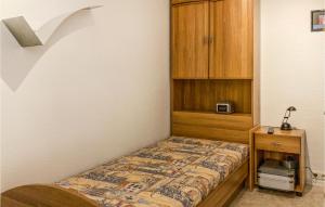 Un dormitorio pequeño con una cama y un armario de madera. en 2 Bedroom Nice Apartment In Schwerin, en Schwerin 5 fotos más