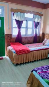 a bedroom with two beds with purple drapes at Rishop Mountain Homestay in Rishop +22 photos