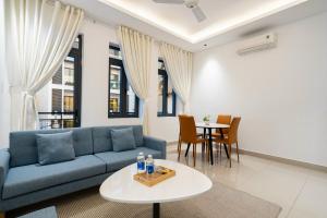 Una sala de estar con un sofá azul y una mesa. en Tin Tin Apartment, en Ho Chi Minh