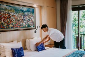 乌布Dewangga Ubud的把枕头放在酒店客房内的床上 更多37张照片