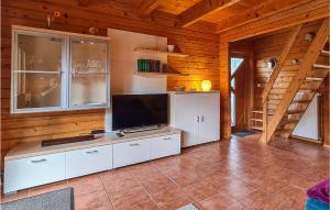 a living room with a television in a wooden cabin at 2 Bedroom Awesome Home In Boiensdorf in Boiensdorf
