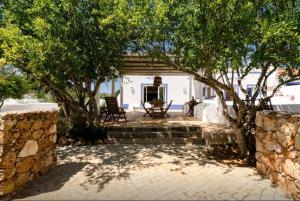 un patio con 2 sillas y árboles en Casa da Nora, en Silves