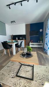 a kitchen and living room with a table and chairs at Apartament SUNNY Rusinowo in Rusinowo
