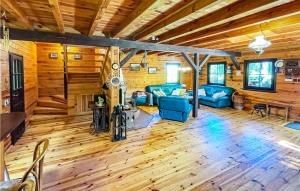 Elle comprend un salon doté d'un mobilier bleu et de murs en bois. dans l'établissement 2 Bedroom Beautiful Home In Nowe Warpno, à Nowe Warpno