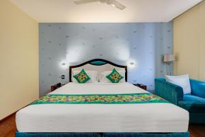 a bedroom with a large bed and a blue chair at HOTEL BLACK & WHITE in Visakhapatnam