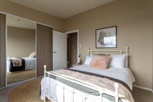 a bedroom with a bed and a large mirror at River Haven serene spacious with river views in Launceston