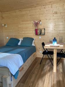 a bedroom with a bed and a table at La tiny house in Saint-Vincent-de-Paul