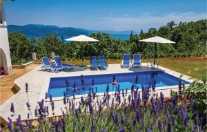 a swimming pool with blue chairs and umbrellas at Nice Home In Brsec With House Sea View in Zagorje